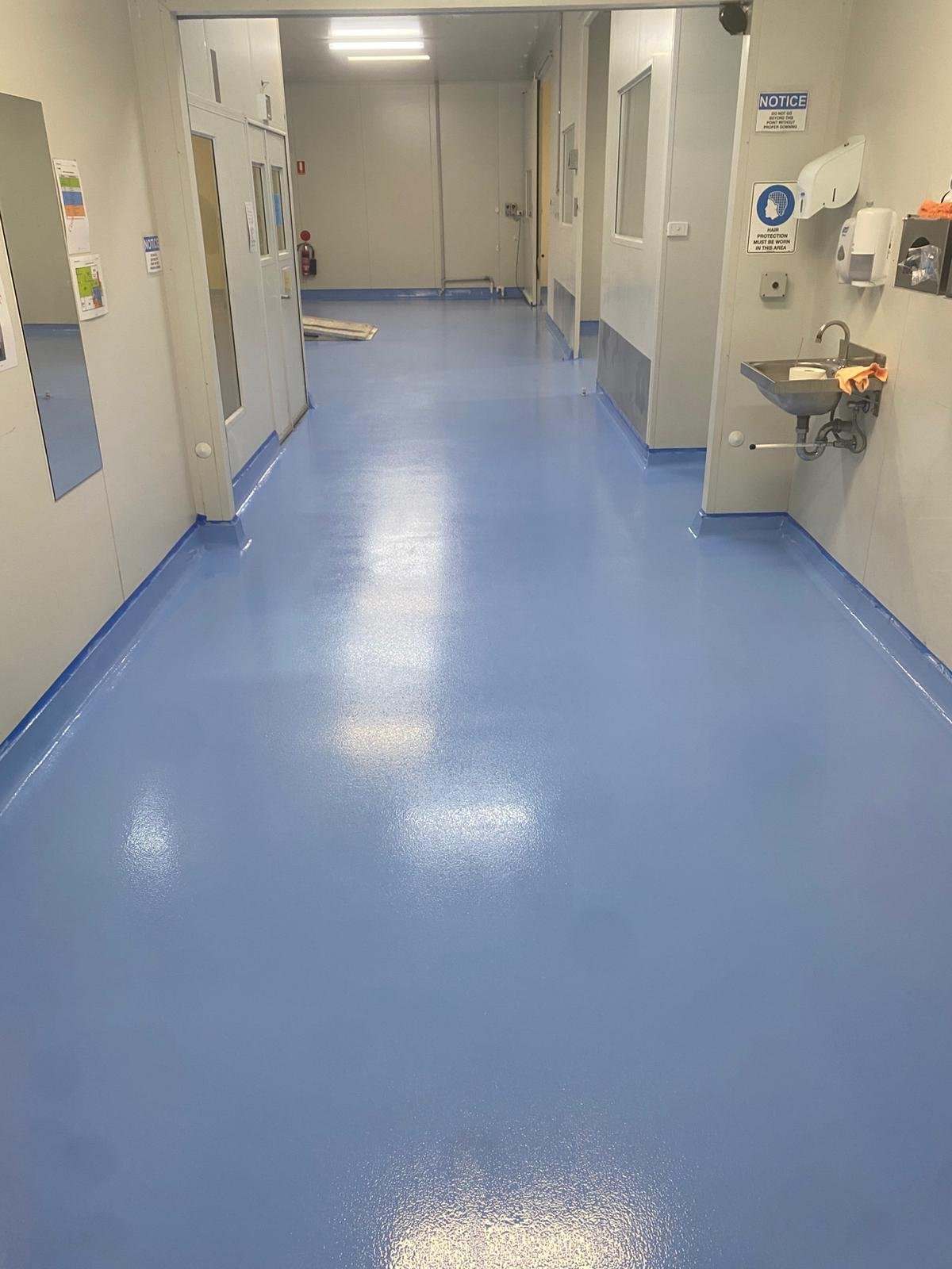 Blue epoxy floor with coved skirtings in a food facility