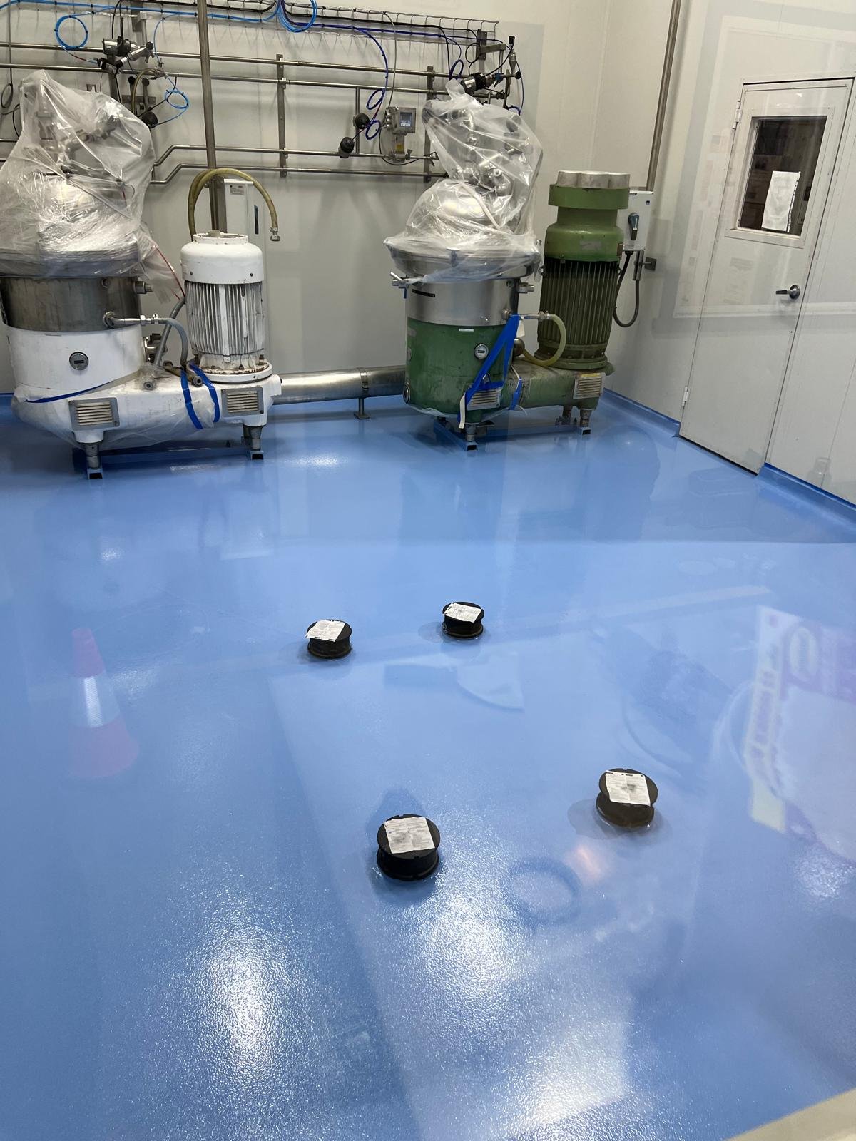 Blue epoxy floor around stainless processing tanks