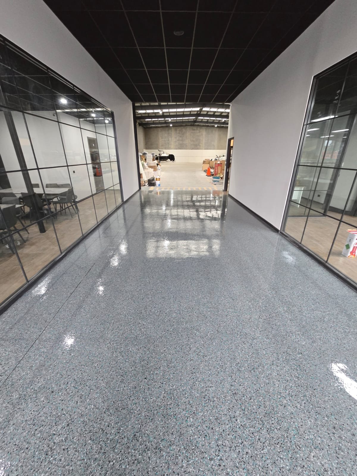 Speckled epoxy flake floor down a warehouse office corridor
