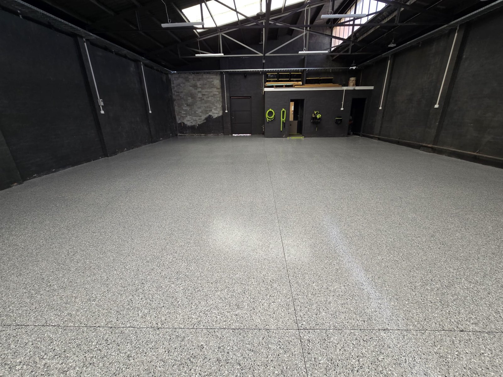 Grey and white epoxy flake floor across a large warehouse
