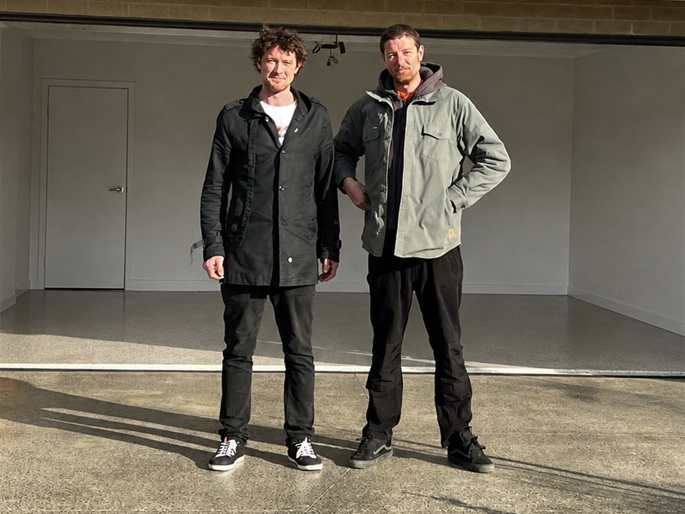 Rowan and Seamus Sercombe, owners of Ozzy Epoxy Broz, standing in a garage they have coated