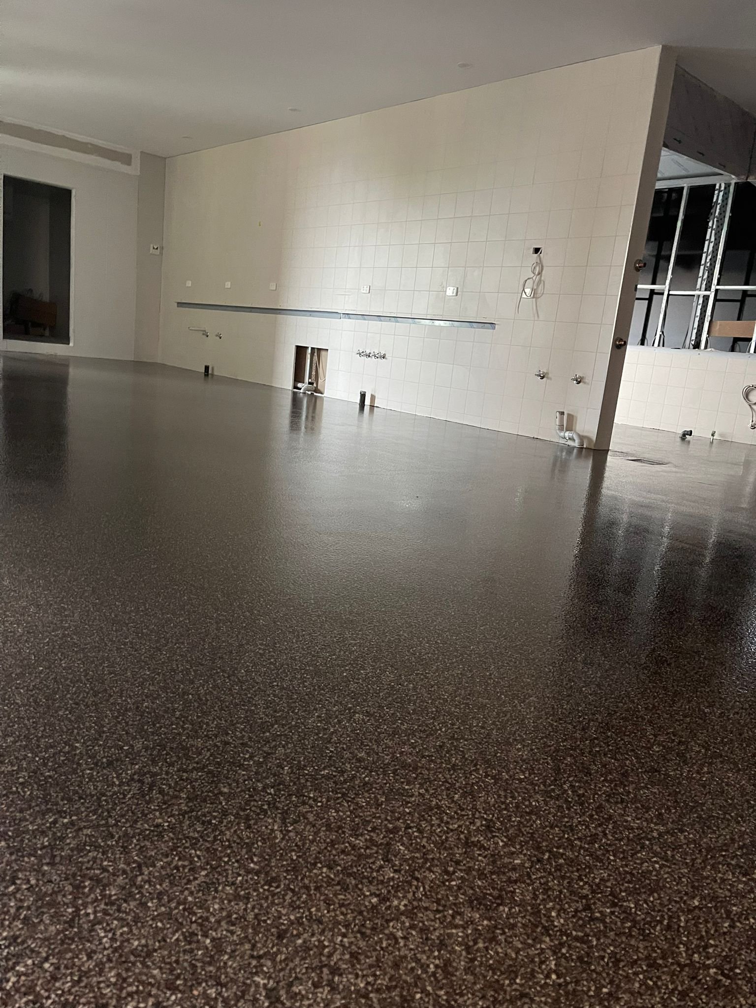 Tan urethane cement floor with flake in a commercial kitchen